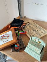 Group shot showing calendar, cutting board, cross, pouch, small framed Kaua'i print