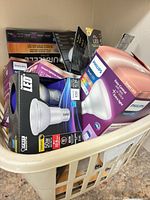 Basket containing multiple boxed Philips LED and Smart LED bulbs