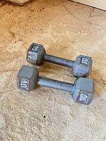 Both dumbbells lying flat showing hex heads with weight markings
