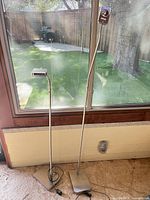 Full view of both metal floor lamps showing height difference and bases