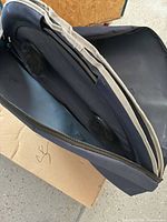 Zippered carrying case partially open showing folded frame and table surface