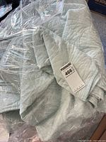 Quilt in plastic wrap with MaxSold tag visible