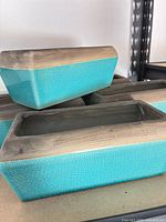 Stacked view of rectangular turquoise planters showing crackle glaze and tan rims