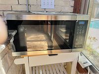 Front view of Samsung stainless steel microwave on cart