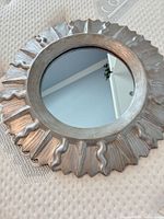 Front view showing silver sunburst frame and mirror