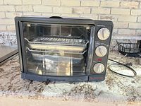 Front view showing toaster oven, controls and accessories inside