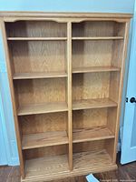 Front view of tall double-column oak bookshelf with shelves installed