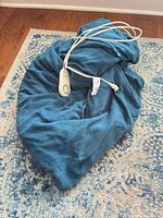 Teal fleece throw bundled with attached white controller