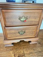 front view of nightstand showing two drawers and brass-tone pulls