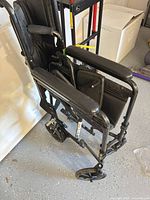 Folded black transport wheelchair side view