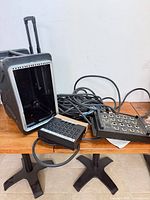Flight case opened with coiled snake cable and two breakout boxes on table