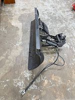 Side view of full plow assembly showing blade curvature, hydraulic mount, hoses