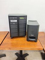 Front view of DiscMakers Reflex duplicator and Bose subwoofer side by side