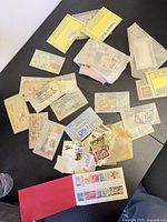 Overview of loose stamps, glassine packets, Falcon envelopes and small sheet in red folder