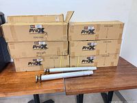 Stacked ProX cartons marked XSQ-3248 with two loose telescoping legs on table