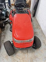 Front view of red riding lawn tractor