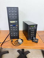 Front view showing both duplicator towers with drives and control panels plus cables