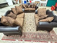 Both sofas facing each other on rug showing overall style, leather trim, cushions and pillows