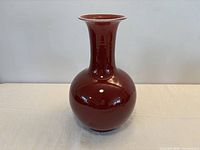 Full view of vase front showing red glaze and shape