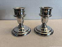Front view of both weighted Birks sterling silver candle holders