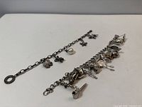 Two sterling silver charm bracelets side by side