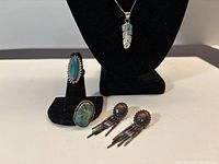 Group shot of two rings, earrings, pendant on display