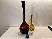 All four coloured glass vases grouped