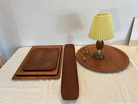 Overall lot showing five teak trays and lamp