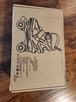 Closed cardboard box showing line art of quad roller skate and product labeling