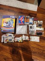 All crafting supplies laid out including construction paper, glue gun, glue sticks, paint kits, pipettes, grommet kit, labels, chalkboards, pens, stamp and ink