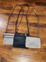 Three crossbody purses laid flat showing full view