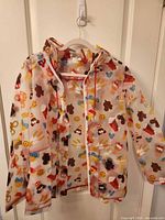 Front view of Disney Parks Snacks rain jacket displayed on hanger