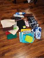 Group view of Singer handheld machine and assorted fabric pieces spread on floor