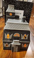 Front view of ceramic haunted house cookie jar with box