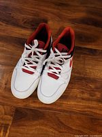 Top view of both white and red Nike sneakers showing laces and toe area