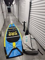 Paddleboard laid out inflated with paddle, pump, carry bag