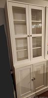 Full view of cabinet showing upper glass doors and lower solid doors