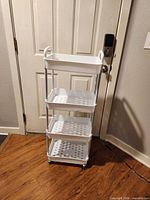 Front view of four-tier white storage cart on wheels