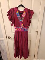 Front view of burgundy embroidered maxi dress on hanger