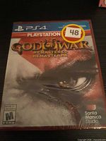 Front view of sealed PS4 God of War Remastered case with shrink wrap and sticker