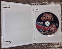 Open Wii game case displaying Super Mario Galaxy disc