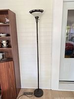 Full view of torchiere floor lamp standing against wall