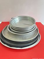 Stacked view of all round pans showing range of materials and sizes
