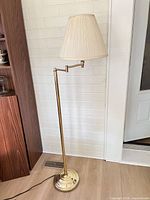 Full view of brass floor lamp with shade