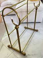 Full angled view of brass freestanding towel rack