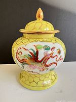 Front view showing dragon motif and yellow crackle glaze jar with lid
