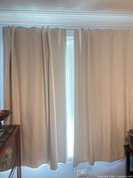 Front view of two ivory curtain panels hanging