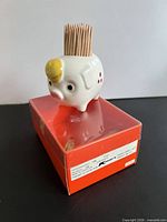 pig toothpick holder standing on original box