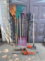 Full group shot of all yard tools and levels standing against door