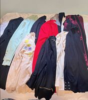 Ten assorted knit cardigans laid out flat showing color range and styles